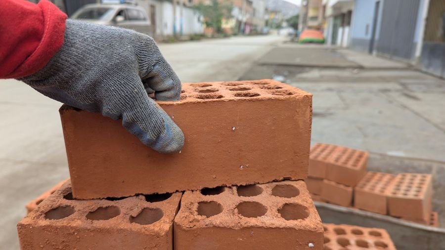Trabajador colocando ladrillos en un sitio de construcción
