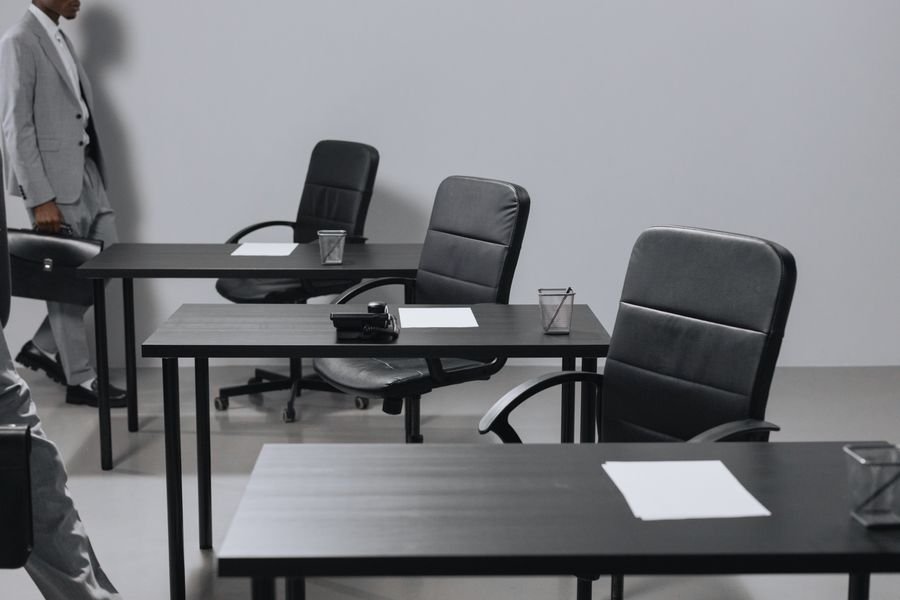 Oficina contemporánea con sillones de piel negros y escritorios