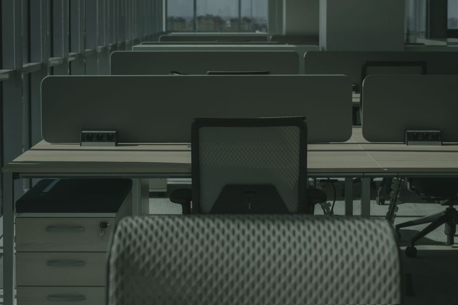 Oficina moderna vacía con múltiples escritorios y sillas ordenados